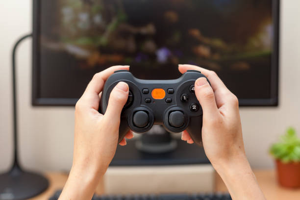 Playing video game with gamepad, close-up.